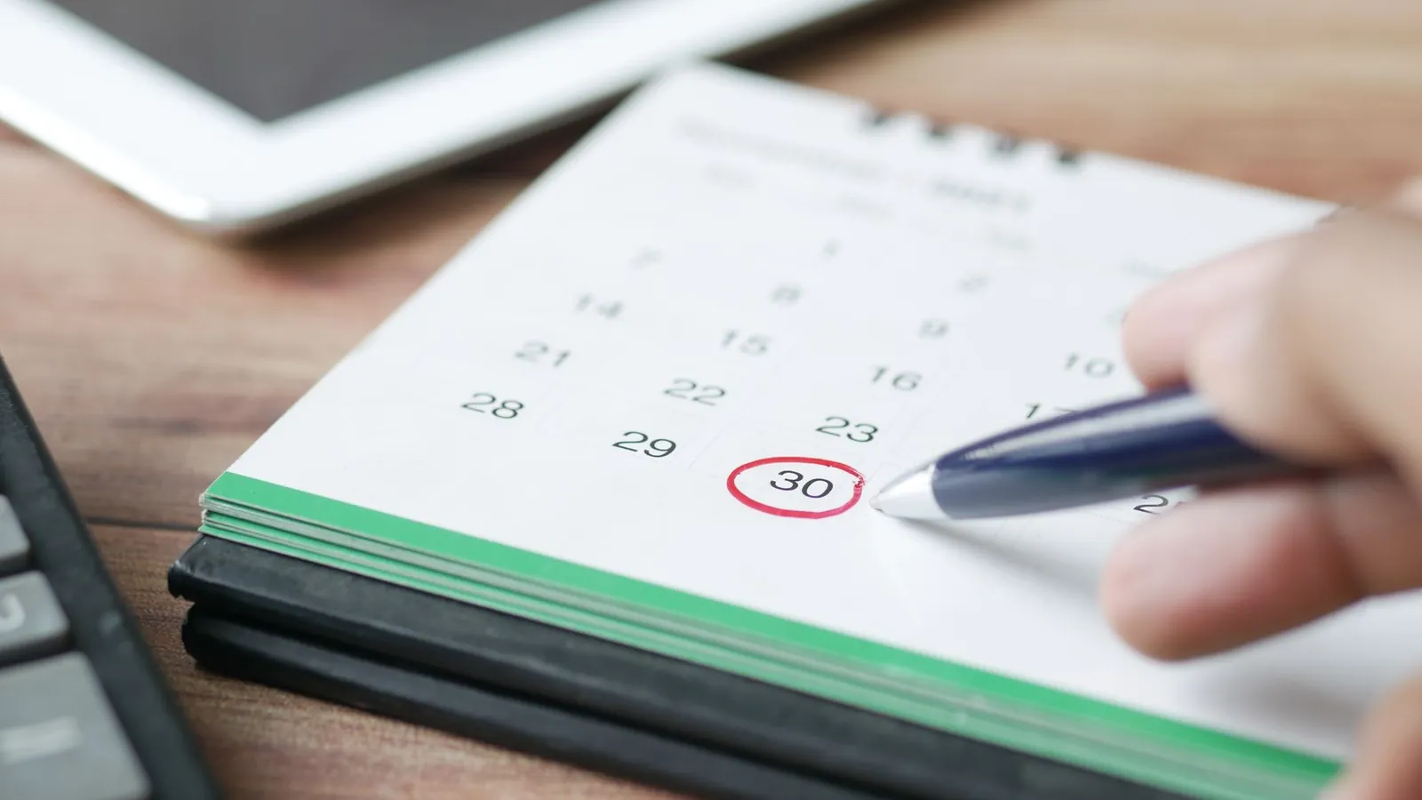 Hand circling a date on a desk calendar to track creditable coverage test, notice, CMS filing and retest deadlines