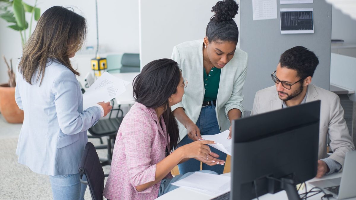 A diverse team of professionals discussing employee health benefits in a modern office