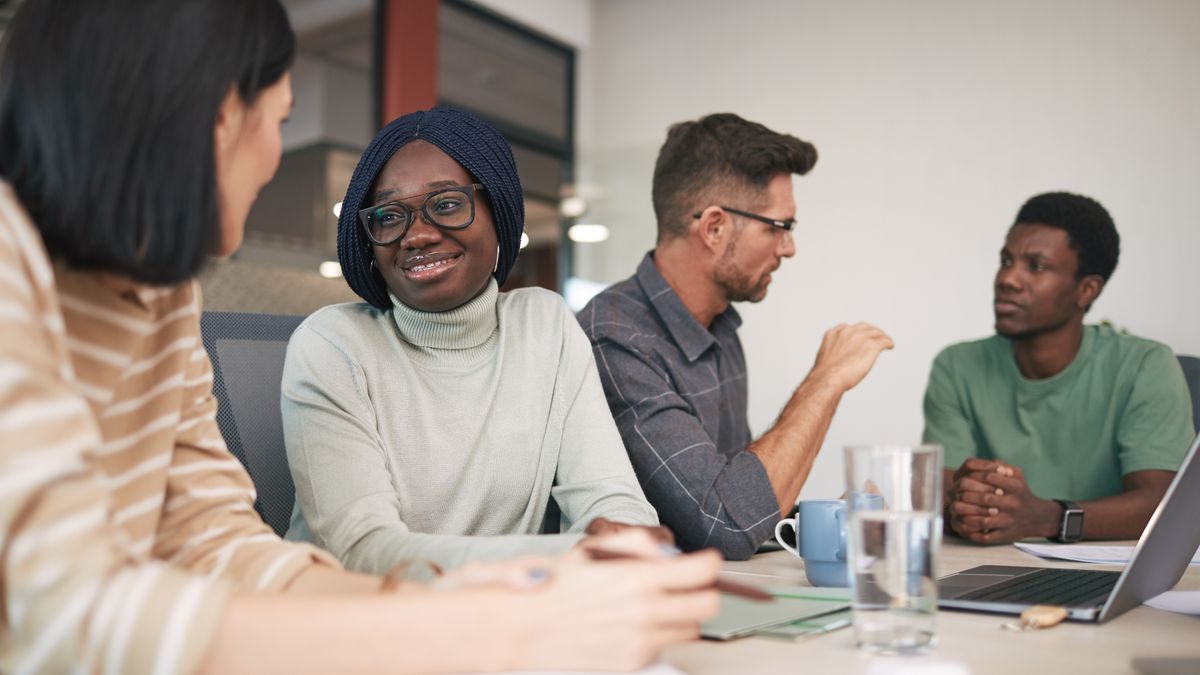 A diverse team of engaged employees collaborating around a table in a modern office