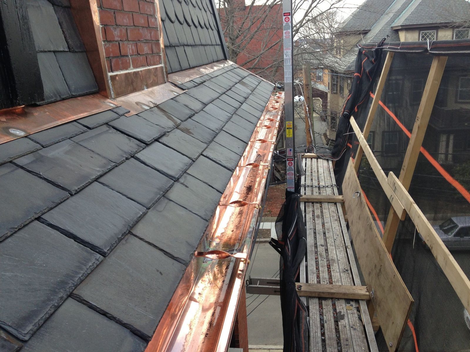 Detail of slate roof tiles with copper gutter in Back Bay Boston