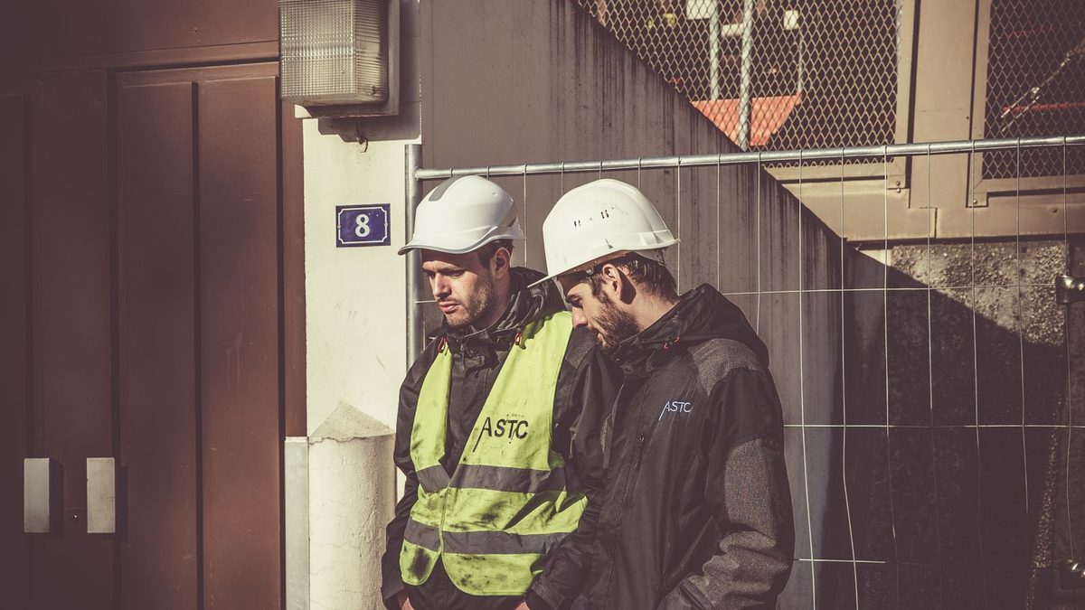 Construction and trade workers in safety gear on a job site