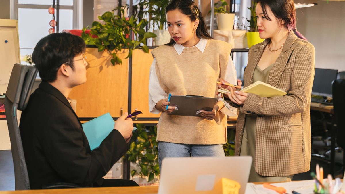 A diverse team of professionals discussing employee health benefits in a modern office