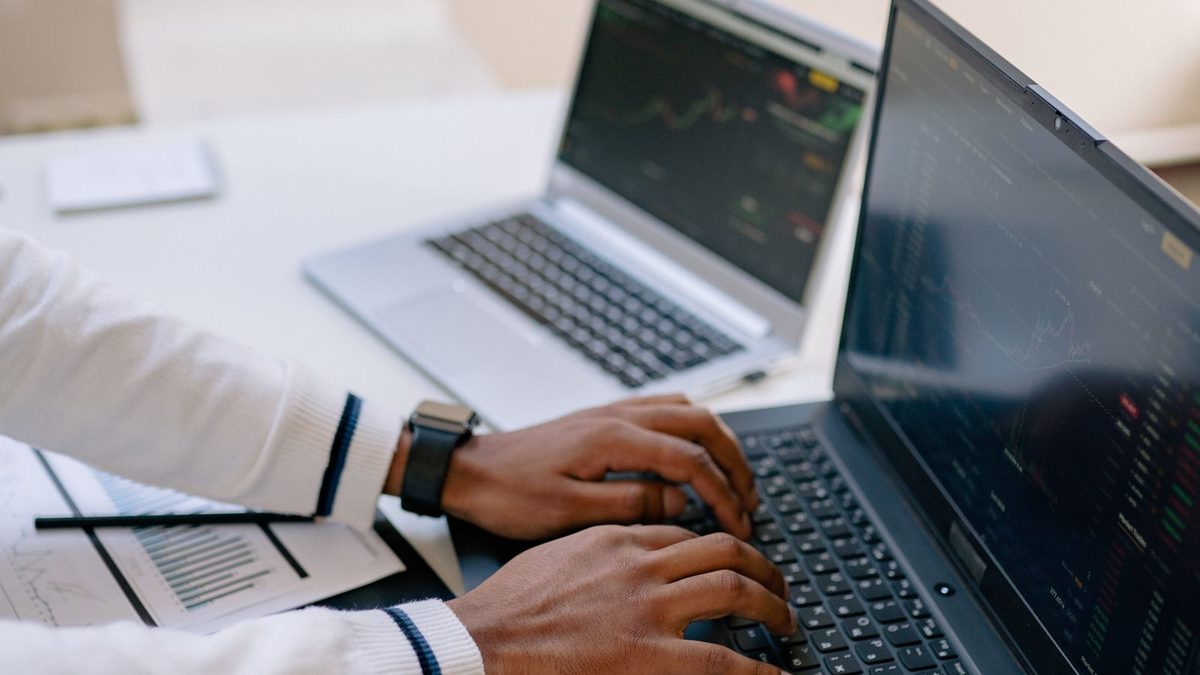 A professional reviewing benefits data and financial charts on a laptop