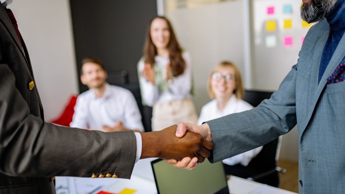 Two professionals shaking hands to finalize a business agreement