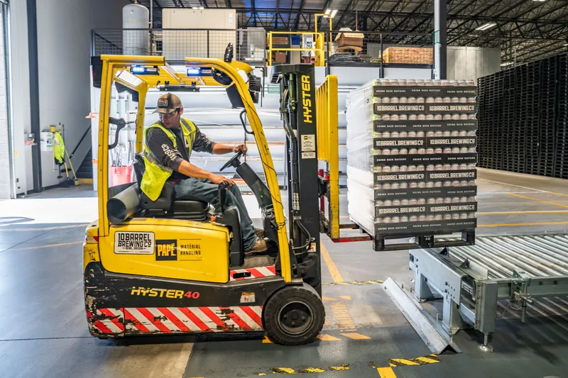 Warehouse employee operating a forklift at a mid-size company weighing captive and level funded health coverage