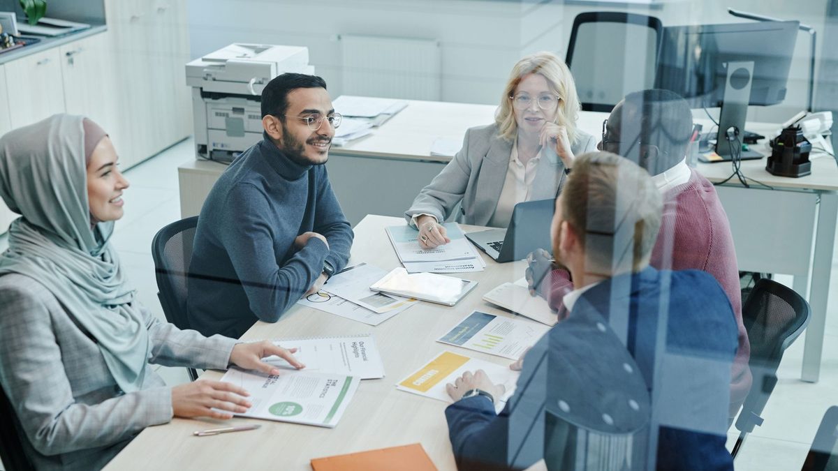 A diverse team of professionals discussing employee health benefits in a modern office