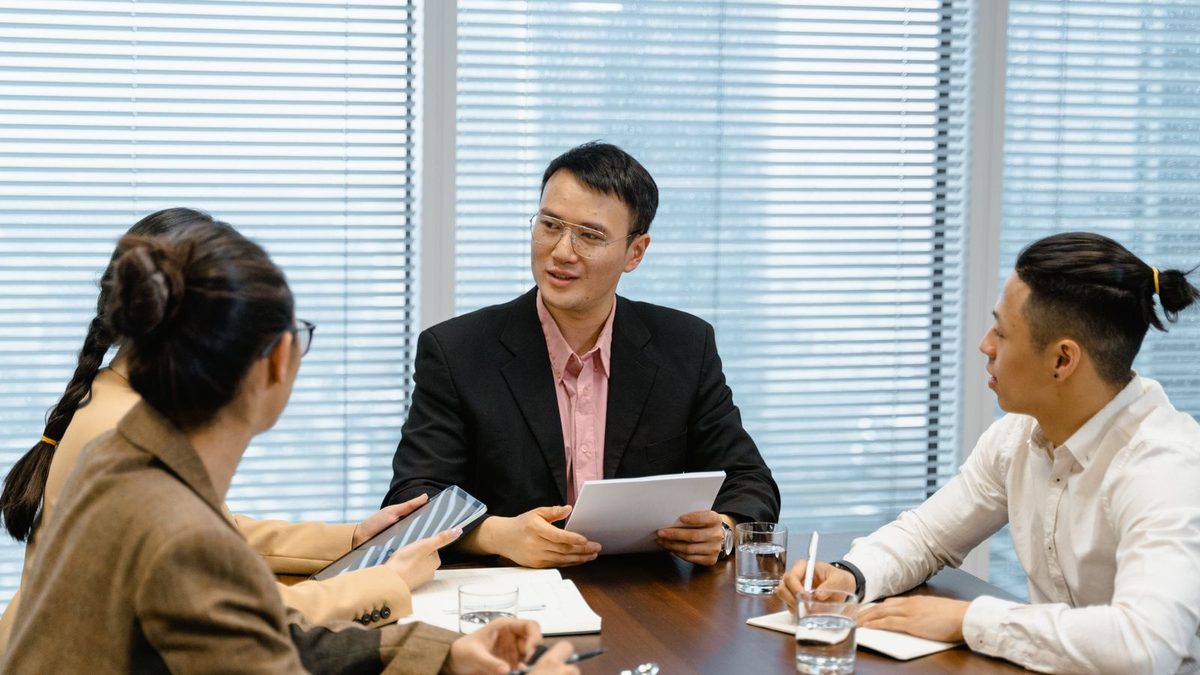 A diverse team of professionals discussing employee health benefits in a modern office