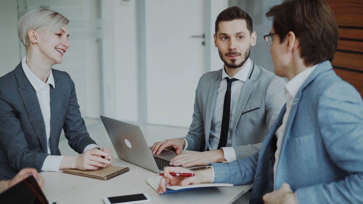 A diverse team of professionals discussing employee health benefits in a modern office