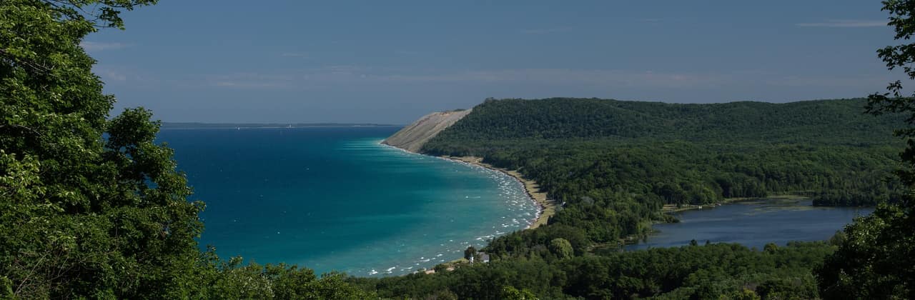 Turquoise Lake Michigan shoreline and wooded bluffs seen from Empire Bluffs at Sleeping Bear Dunes, Michigan