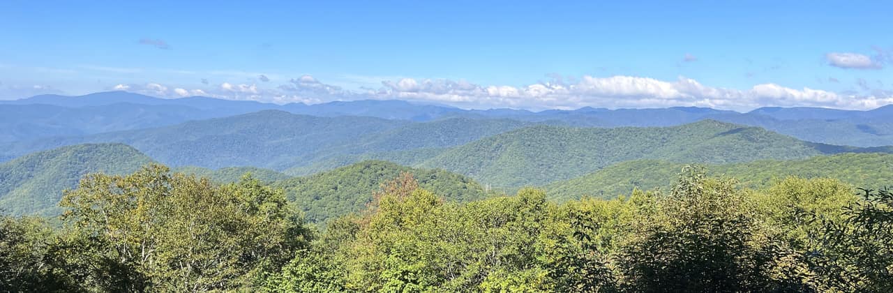 Layered blue-green ridges of the Great Smoky Mountains in North Carolina under a blue sky