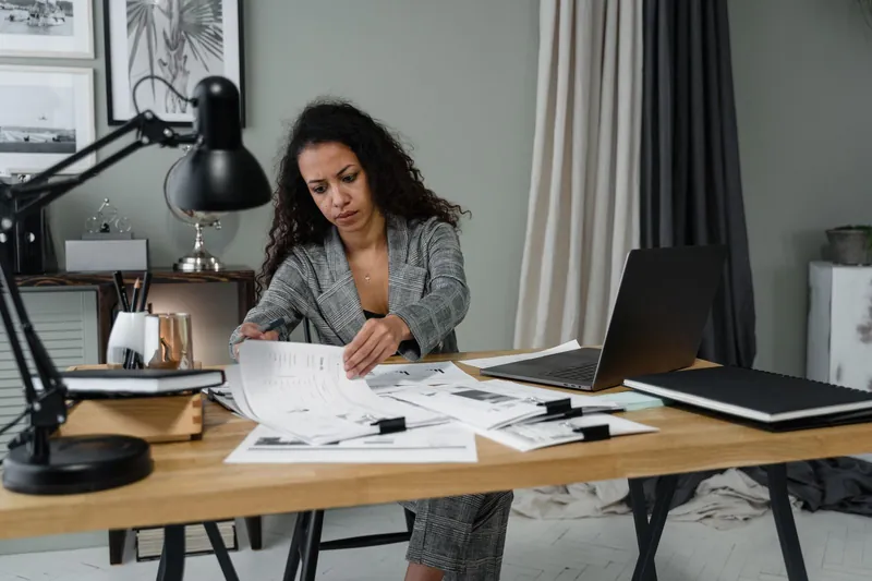 Benefits advisor reviewing claims and renewal paperwork at a desk