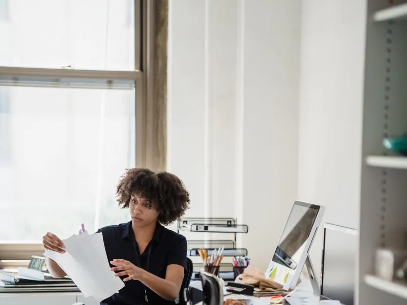 Employer holding a stack of benefits documents while preparing for a renewal decision