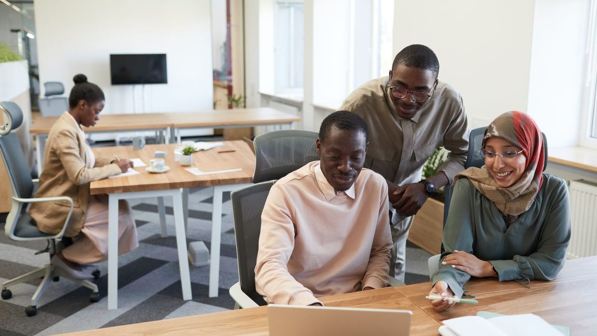 A diverse team of professionals discussing employee health benefits in a modern office
